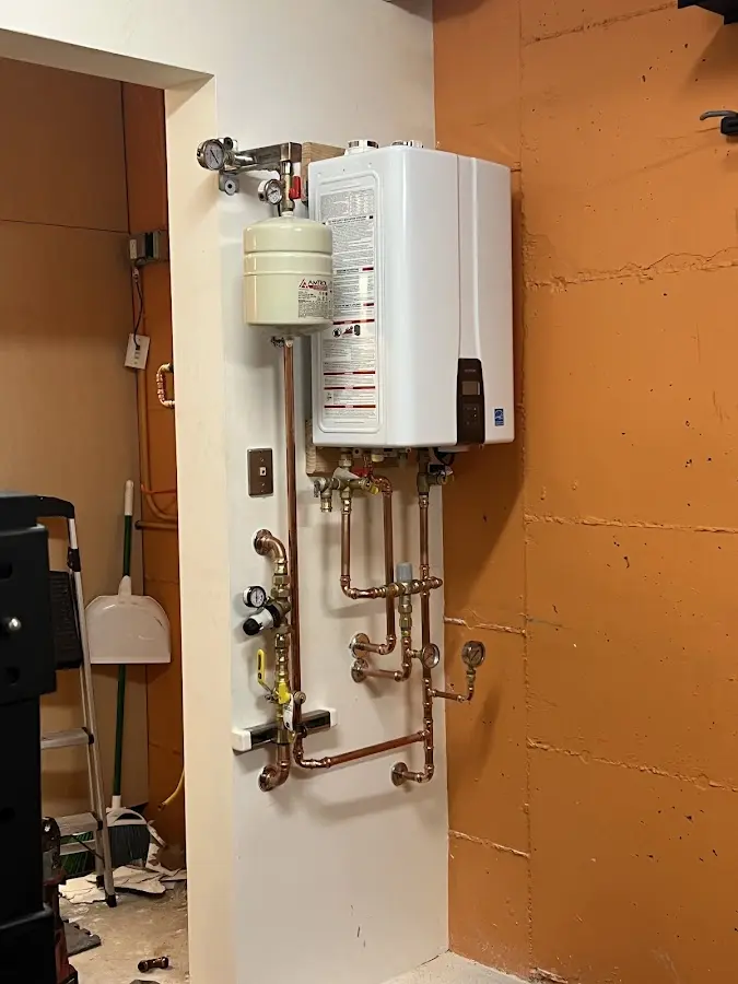 Plumbing technician inspecting water heater connections in Crouch Mesa